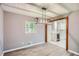 Dining room with modern lighting fixture and view into the updated kitchen at 1679 Hollyhock Ter, Decatur, GA 30032