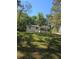 Lush green lawn in front of a single-story white house with a dark trim and covered porch at 1679 Hollyhock Ter, Decatur, GA 30032