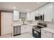 Well-lit kitchen featuring white cabinets, modern appliances and tiled backsplash at 1679 Hollyhock Ter, Decatur, GA 30032