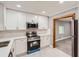 Modern kitchen featuring white cabinets, stainless steel appliances, and tile flooring at 1679 Hollyhock Ter, Decatur, GA 30032