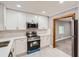 Bright kitchen featuring stainless steel appliances, white cabinets, and view to a living area at 1679 Hollyhock Ter, Decatur, GA 30032