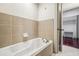 Bathroom featuring a tile surround soaking tub and access to the walk-in closet at 791 Wylie Se St # 102, Atlanta, GA 30312