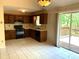 Functional kitchen features white tile flooring, wood cabinetry, and sliding glass doors to the outdoor deck at 997 Timbervale Ln, Lithonia, GA 30058