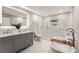 Modern bathroom with double vanity, glass-enclosed shower, and soaking tub, providing a luxurious experience at 1335 Elizabeth Ave Sw, Atlanta, GA 30310