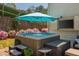 Cozy backyard featuring a hot tub under an umbrella with a wall-mounted TV and brick-paved patio at 2075 Old Georgian Nw Ter, Atlanta, GA 30318