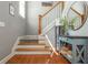 Inviting entryway features hardwood floors, a staircase, and stylish decor with a table and round mirror at 2075 Old Georgian Nw Ter, Atlanta, GA 30318