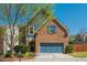 Charming two-story brick home with blue accents, a well-manicured lawn, and a two-car garage at 2075 Old Georgian Nw Ter, Atlanta, GA 30318