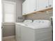 Bright laundry room featuring a washer and dryer with white cabinets and a window with natural light at 2075 Old Georgian Nw Ter, Atlanta, GA 30318