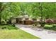 Charming single-story home with a brick facade, covered carport and a long driveway lined with mature trees at 3800 Whitaker Ln, Lithia Springs, GA 30122