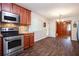 Modern kitchen featuring stainless steel appliances, stone backsplash, wood cabinets and view into dining area at 3800 Whitaker Ln, Lithia Springs, GA 30122