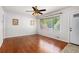 Bright living room featuring hardwood floors, a ceiling fan, and natural light through large windows at 3800 Whitaker Ln, Lithia Springs, GA 30122