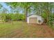 View of outbuilding with a garage door on an ample lot with greenery at 3800 Whitaker Ln, Lithia Springs, GA 30122