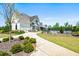 Charming cottage-style home with attached garage and beautifully landscaped yard with a pool in the background at 4105 Woodwind Dr, Cumming, GA 30028