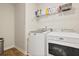 Functional laundry room with white washer and dryer, shelving, and practical flooring at 4105 Woodwind Dr, Cumming, GA 30028
