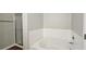 Bathroom featuring a bathtub, shower, and white tiled walls at 5169 Hanover St, Atlanta, GA 30349