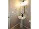 Powder room featuring a pedestal sink, stylish mirror, and modern fixtures at 5169 Hanover St, Atlanta, GA 30349