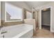 Bathroom with soaking tub, glass enclosed shower, and large window with blinds at 1285 Brynhill Ct, Buford, GA 30518