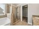 Bathroom with soaking tub, glass enclosed shower, tile flooring, and walk-in closet at 1285 Brynhill Ct, Buford, GA 30518