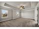 Spacious bedroom with a tray ceiling, ceiling fan, neutral walls, and carpet flooring at 1285 Brynhill Ct, Buford, GA 30518