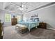 Spacious main bedroom featuring a trey ceiling, ceiling fan, bench seat, and soothing blue bedding at 1326 Benbrooke Nw Ln, Acworth, GA 30101