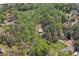 Aerial view showcasing a partially wooded lot with a barn, house, and ample space, nestled among mature trees at 1819 Yorkshire Dr, Woodstock, GA 30189