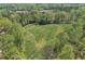 Aerial shot of an expansive green field surrounded by lush trees, showcasing the property's serene and private setting at 1819 Yorkshire Dr, Woodstock, GA 30189