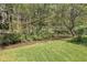 Scenic view of a tranquil creek flowing through a lush, green landscape with a white fence in the background at 1819 Yorkshire Dr, Woodstock, GA 30189