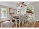 Bright dining room featuring a large window, wood floors, a ceiling fan, and seating for eight at 1819 Yorkshire Dr, Woodstock, GA 30189