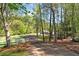 Long driveway leading to a house and barn, complemented by mature trees and a white fence at 1819 Yorkshire Dr, Woodstock, GA 30189