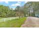 Driveway leading to the home surrounded by white fencing and a well-manicured lawn at 1819 Yorkshire Dr, Woodstock, GA 30189