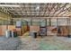 Indoor horse barn featuring three stalls, a metal roof, and black metal stall doors with wood panels at 1819 Yorkshire Dr, Woodstock, GA 30189
