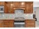 Close-up of the kitchen features including cabinets, granite countertops, tile backsplash, and gas range at 1819 Yorkshire Dr, Woodstock, GA 30189