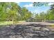 Detached outbuilding on a gravel lot with fencing and mature trees in background at 1819 Yorkshire Dr, Woodstock, GA 30189
