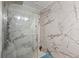 Modern bathroom featuring a glass shower with marble-patterned walls and tiled flooring at 300 Peachtree Ne St # 21H, Atlanta, GA 30308