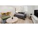 Bright living room with hardwood floors, modern sofa, and dining area with a view from the window at 300 Peachtree Ne St # 21H, Atlanta, GA 30308