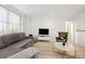 Bright living room with large window, soft sofa, decorative pillows, and modern furnishings at 300 Peachtree Ne St # 21H, Atlanta, GA 30308