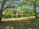 Charming home with a lush green lawn and mature trees providing shade at 69 N Hearn Rd, Ellenwood, GA 30294