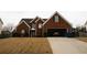Charming brick home with a two-car garage and a well-manicured front lawn at 7881 Chadwick Ln, Riverdale, GA 30274