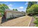 Exterior showcasing a concrete patio, multiple windows, and a manicured backyard with greenery and trees at 1330 Badingham Dr, Cumming, GA 30041