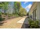 Backyard landscaping with mature trees and shrubs and a patio area that spans the length of the house at 1330 Badingham Dr, Cumming, GA 30041