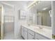 Bright bathroom featuring a double sink vanity, storage cabinet, and tiled floors and a window with natural light at 1330 Badingham Dr, Cumming, GA 30041