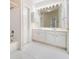 All-white bathroom with tile flooring, double vanity, and a shower and tub combination in background at 1330 Badingham Dr, Cumming, GA 30041