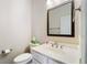 Half bathroom featuring toilet and sink with mirror and a box of tissues at 1330 Badingham Dr, Cumming, GA 30041