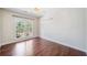 Bedroom with hardwood floors, fan and a large window overlooking the landscaped yard at 1330 Badingham Dr, Cumming, GA 30041