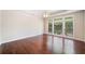 Large bedroom featuring hardwood floors, tray ceiling, and lots of natural light through the window at 1330 Badingham Dr, Cumming, GA 30041