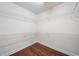 Walk-in closet features custom shelving for ample storage space and hardwood flooring at 1330 Badingham Dr, Cumming, GA 30041