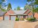 Charming brick home featuring a two-car garage, landscaped yard, and inviting front entrance at 1330 Badingham Dr, Cumming, GA 30041