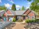 Charming brick home featuring a two-car garage, well-kept lawn, and lovely landscaping at 1330 Badingham Dr, Cumming, GA 30041