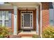 Covered front entry featuring a decorative door with sidelights and a brick surround at 1330 Badingham Dr, Cumming, GA 30041