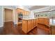 Open kitchen featuring an island, wooden cabinets, stainless steel appliances, and hardwood flooring at 1330 Badingham Dr, Cumming, GA 30041